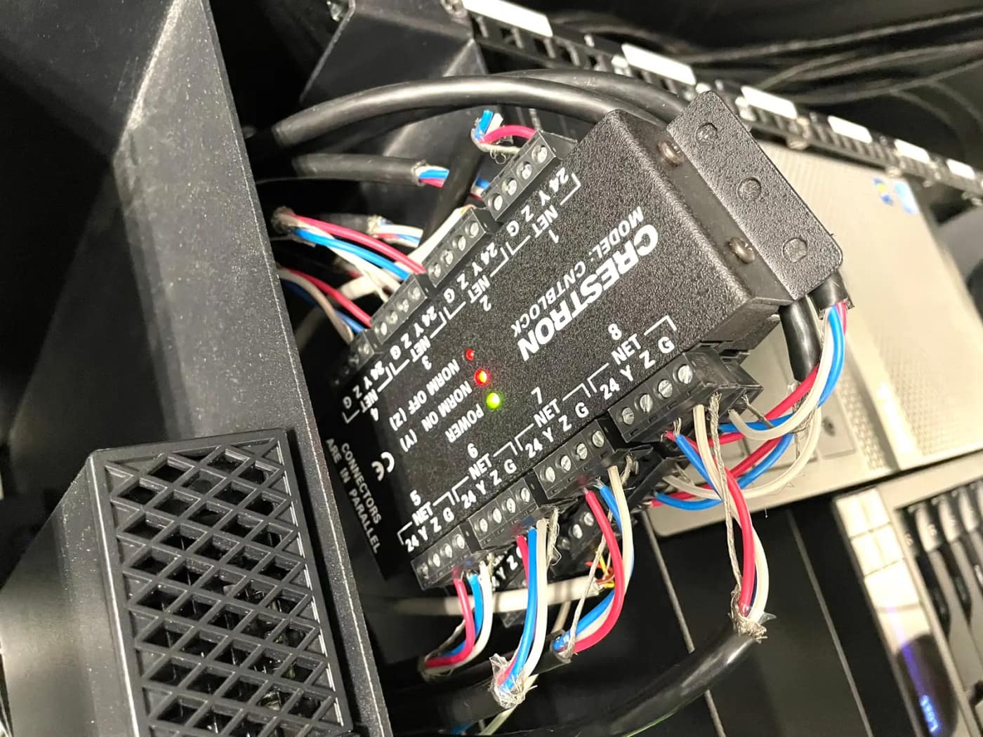 Módulo de automação Crestron instalado no rack, com a fiação identificada.