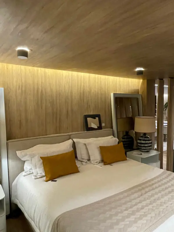 Quarto da Mostra Magna Audio, com forro de madeira, luz indireta e caixa de som de sobrepor no teto.
