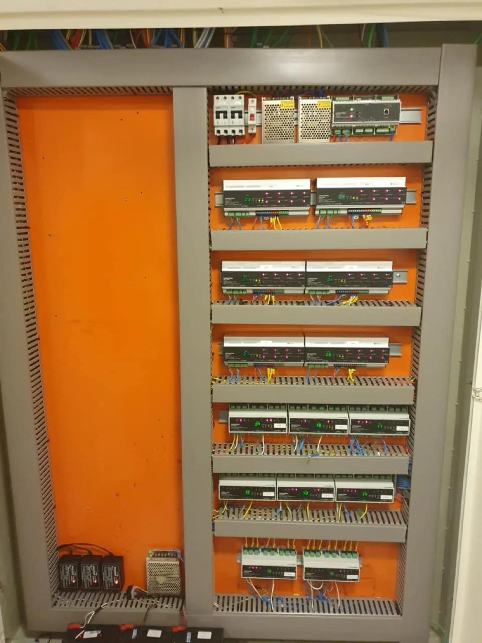 Quadro de automação aberto, com módulos em trilho e proteção elétrica.