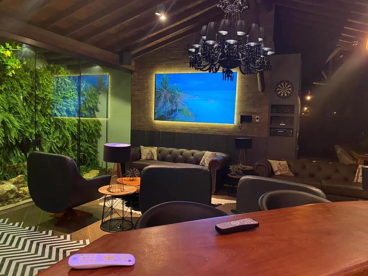 Lounge com tela de projeção iluminada por trás e projetor.