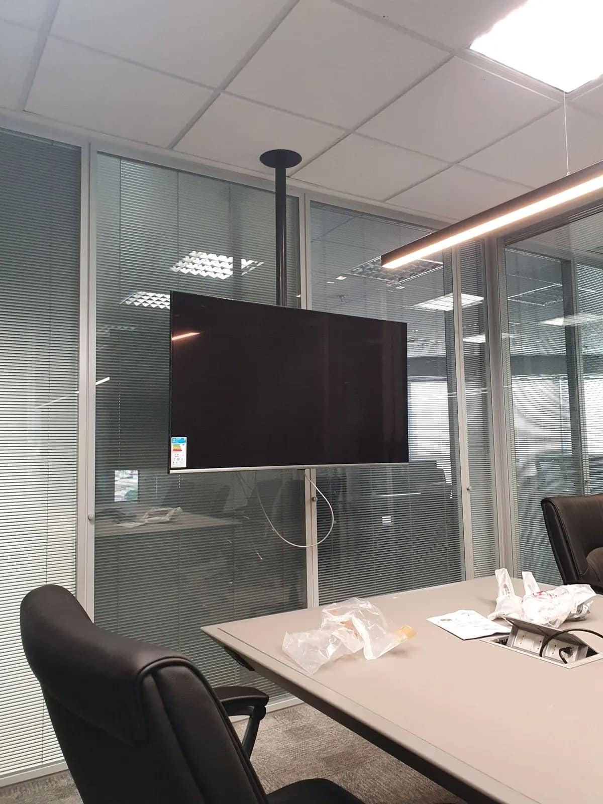Monitor em suporte de coluna, posicionado para a mesa inteira.