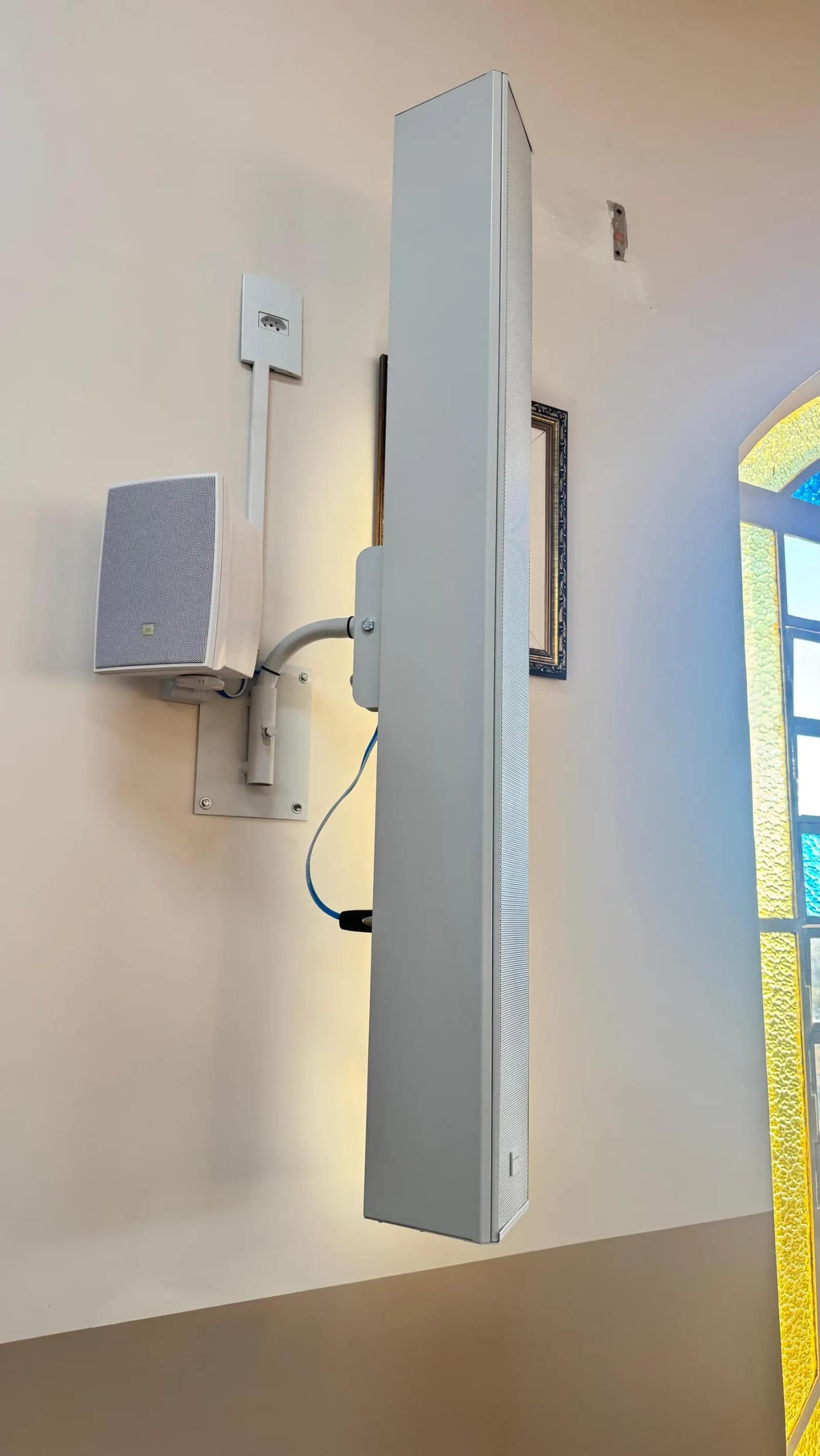 Caixa coluna instalada em parede, com cabeamento embutido.