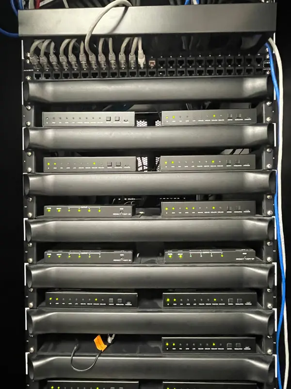 Rack de equipamentos organizado, com as frentes alinhadas e o cabeamento de rede penteado no alto.