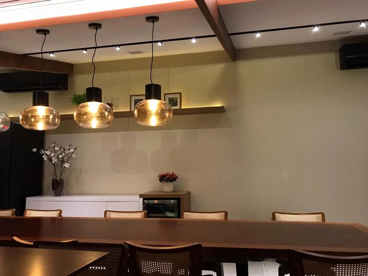 Bancada com pendentes e luz de cena ao anoitecer.