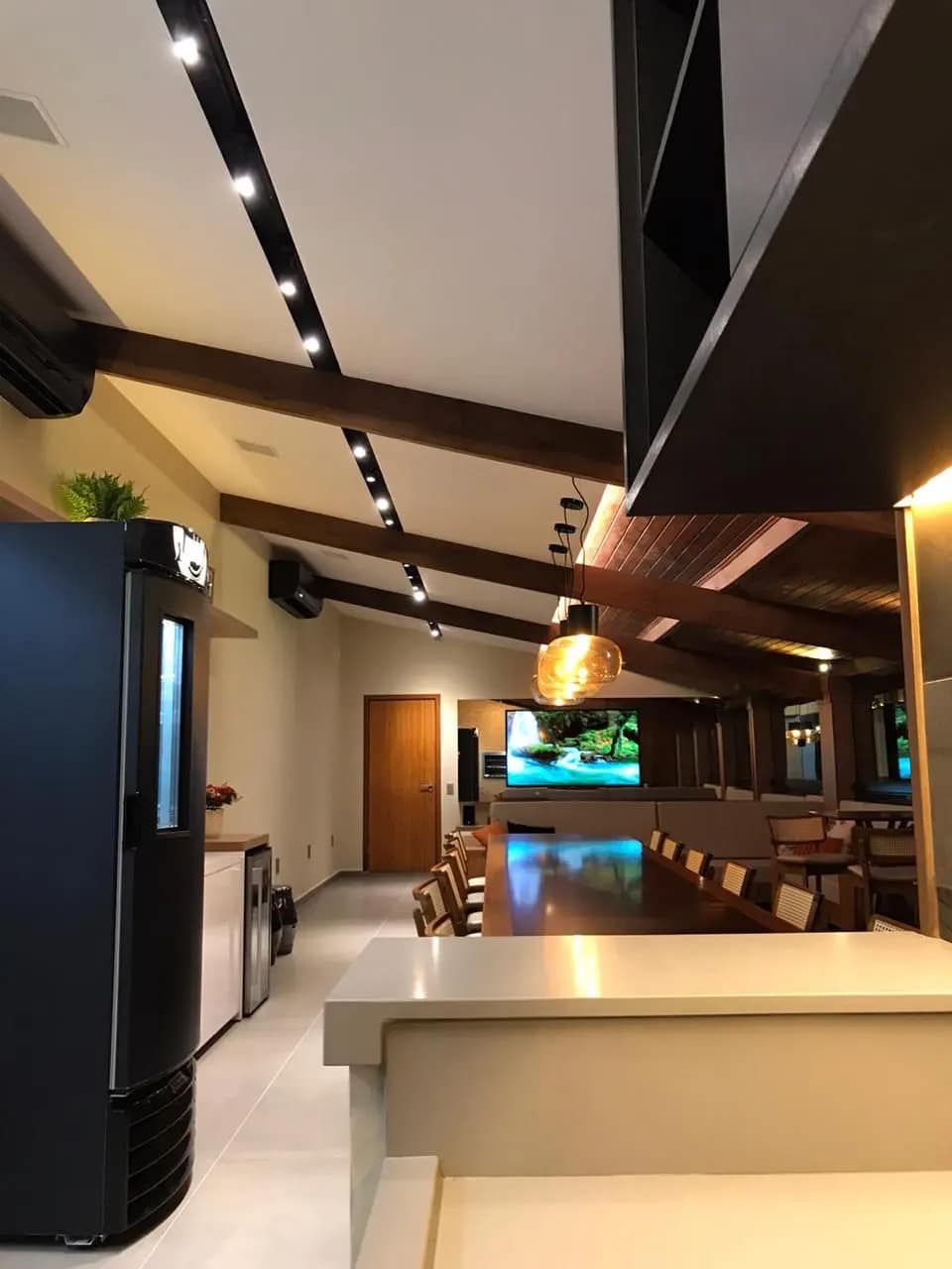 Corredor da área gourmet com iluminação em trilho.