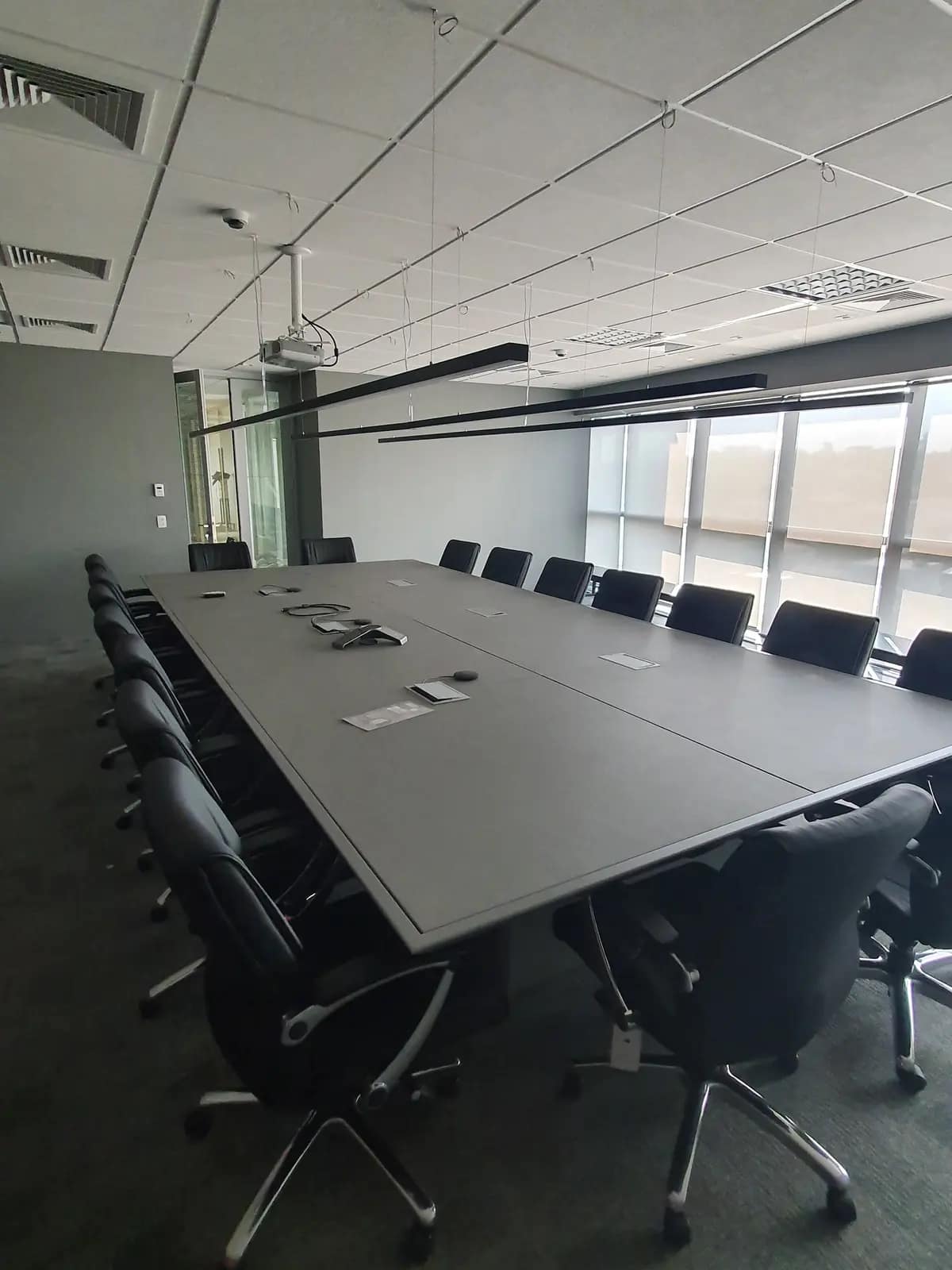 Sala de reunião de mesa longa com janelas.
