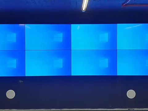 Video wall de oito telas aceso em parede escura.