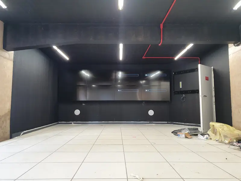 Video wall montado e desligado, com a sala ainda em obra e materiais no piso.